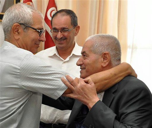 Houcine Abassi secretary general of the Tunisian General Labour Union, right is congratulated by unidentified union members in his office at the headquarters in Tunis Tunisia Friday Oct. 9 2015. Abassi is one of the four members of the Tunisi