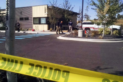 Police and fire investigators stand near the Planned Parenthood clinic in Pullman Wash. after it was damaged by a fire Friday Sept. 4 2015