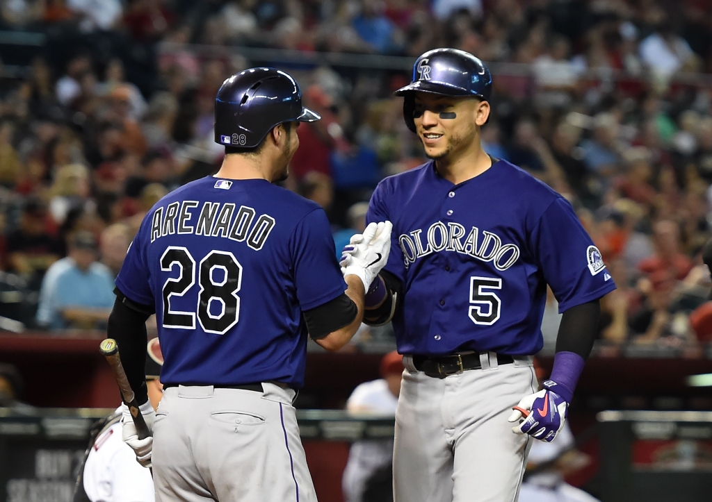 Carlos Gonzalez of the Colorado Rockies celebrates with teammate Nolan Arenado after hitting a third inning home run against the Arizona Diamondbacks at Chase Field on Sept. 29 2015