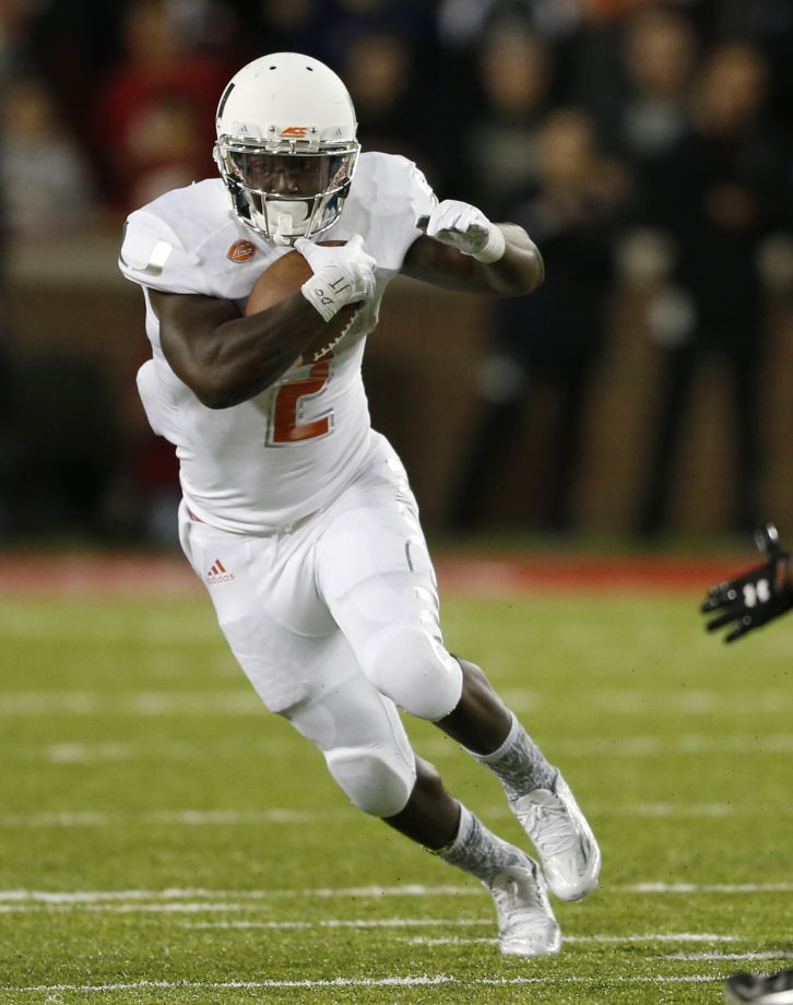 Miami running back Joseph Yearby finds a hole against Cincinnati during the first half of an NCAA college football game in Cincinnati. Florida State's Dalvin Cook and Miami's Joseph Yearby are the top two runni