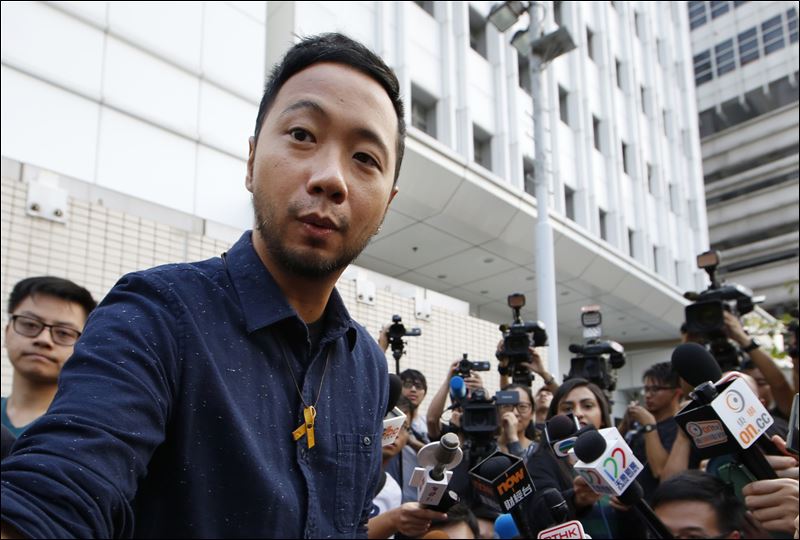 The activist Ken Tsang right reports to a police station in Hong Kong today. Hong Kong police on Thursday charged seven officers with harming an activist who was beaten in a filmed confrontation that stirred outrage among city residents at the height