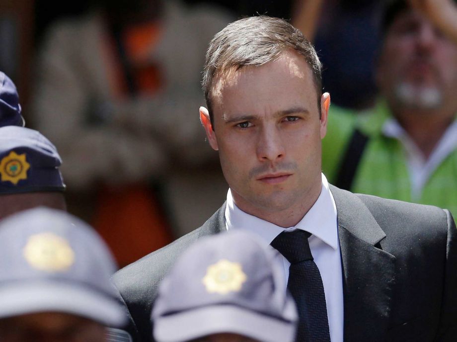 Oscar Pistorius is escorted by police officers as he leaves the high court in Pretoria South Africa. A South African official says Oscar Pistorius has been released from prison and placed under house arres