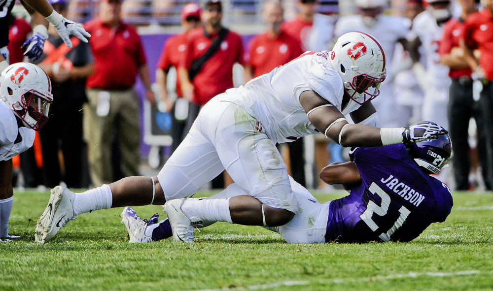 Stanford defensive end Aziz Shittu left takes down Northwestern running back Justin Jackson during an NCAA college football against Northwestern in Evanston Ill