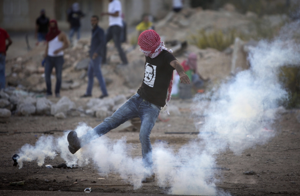 Palestinian kicks a tear gas canister that was fired by Israeli troops during clashes near Ramallah West Bank on Thursday