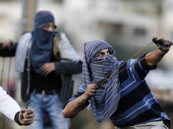 A Palestinian use a handmade slingshot to hurl a stone during clashes with Israeli troops near Ramallah West Bank Tuesday Oct. 27 2015