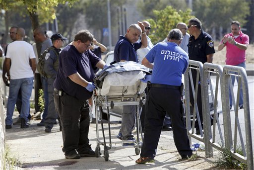 The body of an alleged Palestinian attacker is removed from the scene in Jerusalem Saturday Oct. 17 2015. Police spokeswoman Luba Samri said a 16-year-old Palestinian drew a knife on officers when they approached him in Jerusalem and asked for identifi