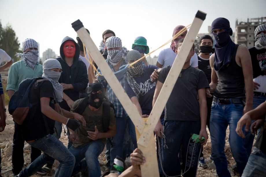 Palestinians uses a handmade large slingshot to hurl a stone during clashes with Israeli troops near Ramallah West Bank Monday Oct. 12 2015. Recent days have seen a series of stabbing attacks in Israel and the West Bank that have wounded several Israe