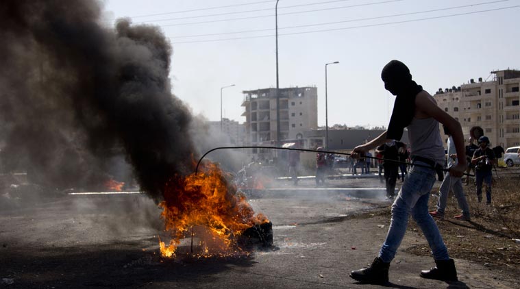 Palestinians burn tires during clashes with Israeli troops near Ramallah West Bank Friday Oct. 16 2015