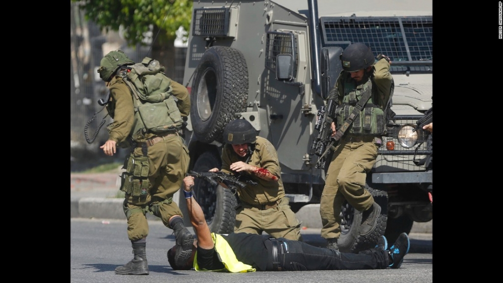 An Israeli soldier runs to help another who was just stabbed by an alleged Palestinian assailant seen on the ground holding a knife during clashes in Hebron West Bank on Friday October 16. In recent weeks there has been a spike in violence across Is