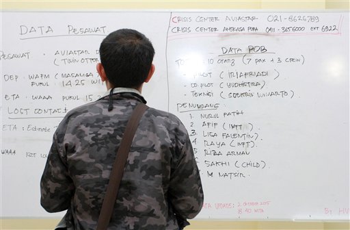 A man inspect a white board with details about a plane that went missing on Sulawesi Island, at the crisis center at Sultan Hasanuddin airport in Makassar South Sulawesi Indonesia Friday Oct. 2 2015. Transportation Ministry spokesman Julius Barata