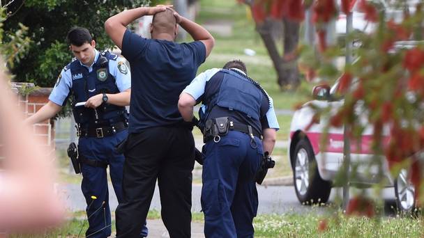 Police search a man and his vehicle near a house in Guildford Sydney