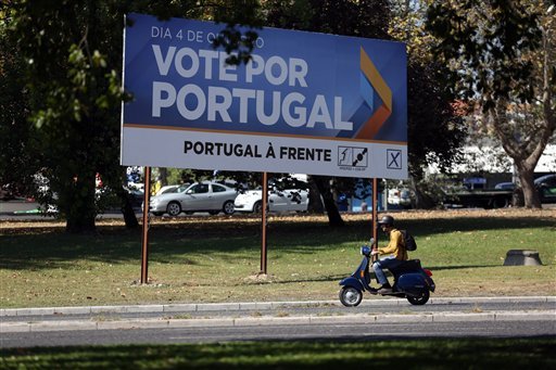 A scooter drives past an election campaign poster of the ruling center-right coalition