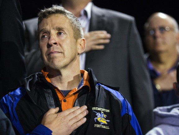 Coach Joe Kennedy listens to the national anthem from the stands at Memorial Stadium in Bremerton Wash. last night