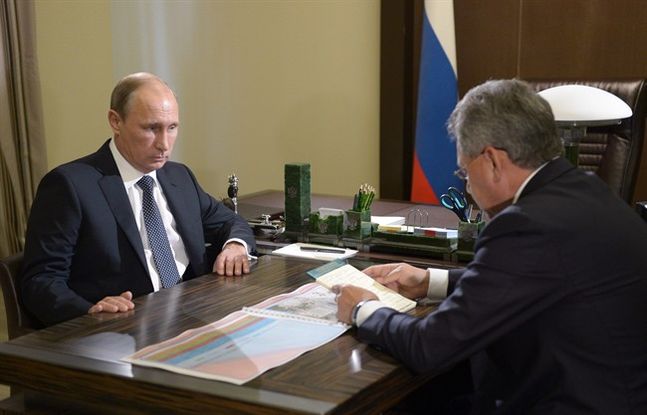 Russian President Vladimir Putin left listens to Defense Minister Sergei Shoigu during their meeting in the Bocharov Ruchei residence in the Black Sea resort of Sochi Russia Wednesday Oct. 7 2015. Shoigu on Wednesday told President Vladimir Putin