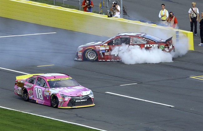 Kyle Busch drives past Kyle Larson on pit road during the NASCAR Sprint Cup series auto race at Charlotte Motor Speedway in Concord N.C. Sunday Oct. 11 2015