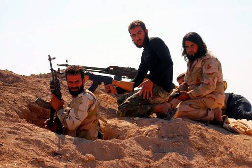 Rebel fighters carry their weapons as they take positions in the town of Kafr Nabudah in Hama province Syria