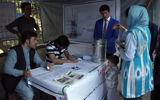 A woman donates money at a tent of the Afghanistan 3rd Trend a civil organization to help displaced people from Kunduz as its staff members work in Kabul Afghanistan Monday Oct. 5 2015. Mohammad Omer Safi the sacked former governor of Kunduz whose