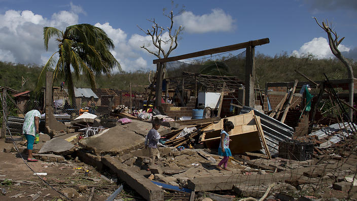 Residents walk through the debris of homes destroyed by Hurricane Patricia in Chamela 
    
    
                
          
          Show