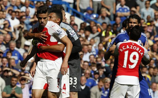 Arsenal's Gabriel left is held by teammate Arsenal's Francis Coquelin after a clash with Chelsea's Diego Costa second right who is being moved away by Arsenal's Santi Cazorla during the English Premier League soccer match between Ch