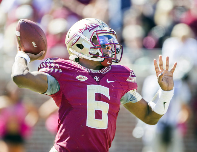 Florida State quarterback Everett Golson throws in the first half of an NCAA college football game against Louisville in Tallahassee Fla. Saturday Oct. 17 2015. Florida State wide receiver Travis Rudolph is swarmed by Louisv