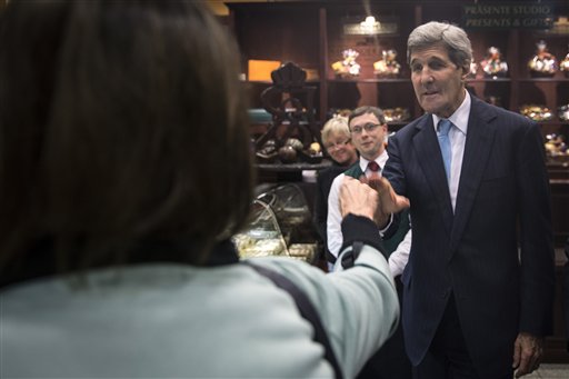 United States Secretary of State John Kerry shakes hands with a woman at chocolate store Fassbender and Rausch during an unscheduled stop in Berlin