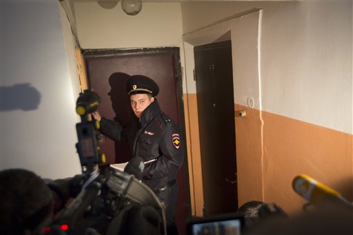 A Russian policeman speaks to the media in the building where homemade explosives were found in an apartment in Moscow Russia Monday Oct. 12 2015. Russia's counterterrorism agency says it has raided a Moscow apartment and arrested a group of peo