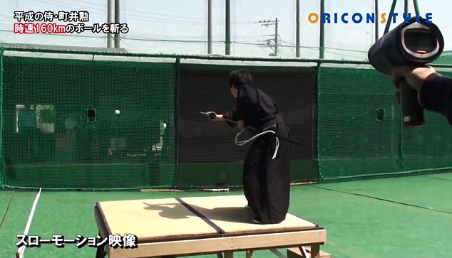 Samurai Isao Machii prepares to slice a baseball in half as it travels towards him at 100mph