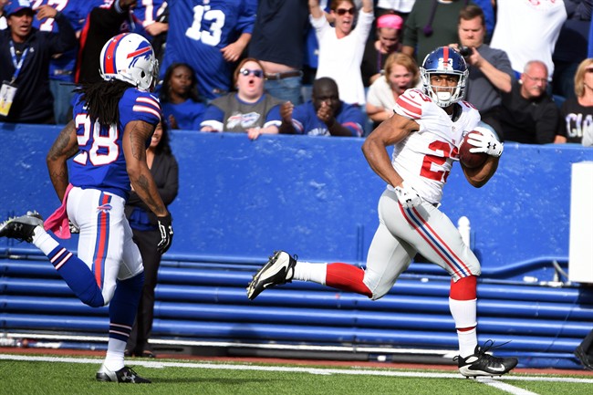 New York Giants running back Rashad Jennings right looks at Buffalo Bills cornerback Ronald Darby left as he scores on a touchdown run during the second half of an NFL football game Sunday Oct. 4 2015 in Orchard Park N.Y