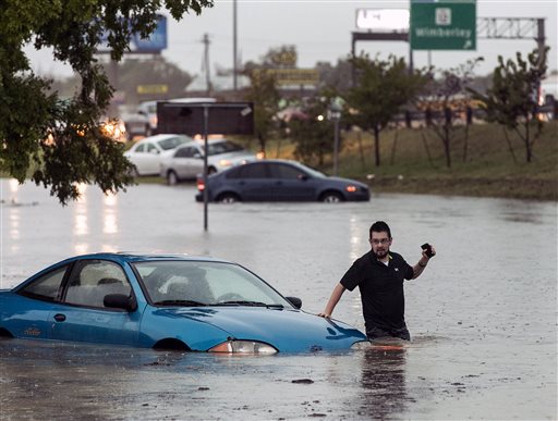 Mike Stoner gets out of his flooded car Friday Oct. 30 2015 in San Marcos Texas. A fast-moving storm packing heavy rain and destructive winds overwhelmed rivers and prompted evacuations Friday in the same area of Central Texas that saw devastating spr