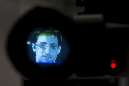 American whistleblower Edward Snowden is seen through a camera viewfinder as he delivers remarks via video link from Moscow to attendees at a discussion regarding an International Treaty on the Right to Privacy Protection Against Improper Surveillance