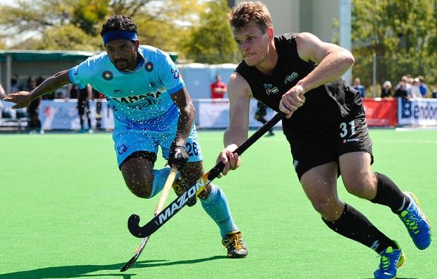 Steve Edwards of the Black Sticks is tackled by Birendra Lakra of India