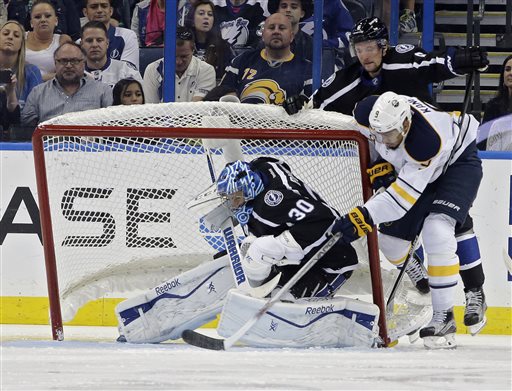 Tampa Bay Lightning goalie Ben Bishop ducks as the goal gets knocked over by Buffalo Sabres left wing Evander Kane and Lightning's Anton Stralman, of Sweden during the second period of an NHL hockey game Saturday Oct. 17 2015 in Tamp