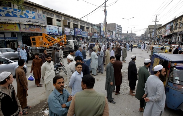 People standing outside their homes and shops during an earthquake in Peshawar Pakistan Monday