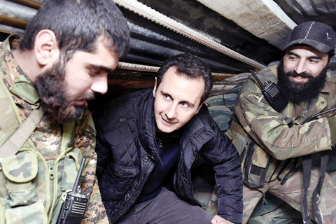 Syrian President Bashar Assad center speaks with Syrian troops during his visit to the front line in the eastern Damascus district of Jobar Syria