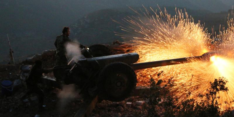 Syrian army personnel fire a cannon in Latakia province close to the Turkish border in Syria