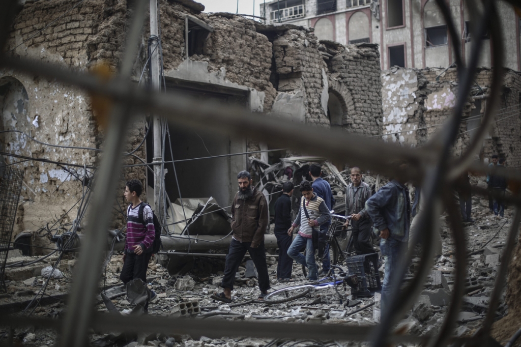 Syrians look at a destroyed field hospital in the rebel-held area of Douma in Syria