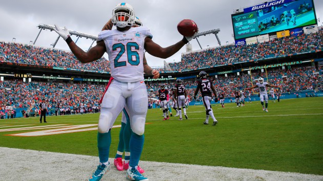 MIAMI GARDENS FL- OCTOBER 25 Lamar Miller #26 of the Miami Dolphins celebrates his touchdown in the second quarter against the Houston Texans at Sun Life Stadium