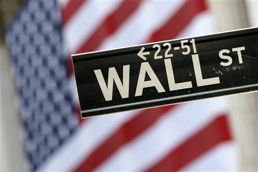 Wall Street street sign is framed by a giant American flag hanging on the facade of the New York Stock Exchange. European stock markets recovered their poise Tuesday Sept. 29 2015 despite an earlier rout in A