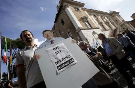 A man holds a cardboard cut-out of Rome Mayor Ignazio Marino during a protest in front of Rome's city hall