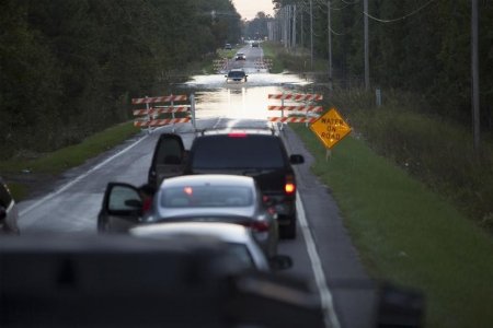 Cars wait in line to pass a flooded section of Dunbar Road in Georgetown South Carolina