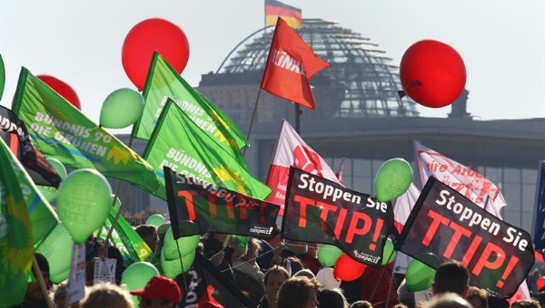 Protesters carry banners and balloons during a rally against the trade agreements TTIP and CETA near the German