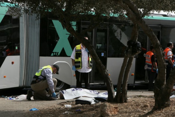 AFP  GALI TIBBONIsraeli emergency personnel stand next to the body of a victim following a shooting attack on a bus in the Jerusalem neighbourhood of Armon Hanatsiv