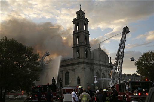 Chicago firefighters work at the scene of an extra-alarm fire at Shrine of Christ the King Church at 64th Street and Woodlawn Avenue in Chicago on Wednesday Oct. 7 2015. About 150 firefighters responded when flames engulfed the 92-year-old church on Chi