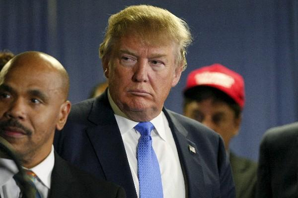 US Republican presidential candidate Donald Trump surrounded by members of Atlanta's black clergy listens at a news conference before a rally in Norcross Georgia