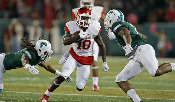 Demarcus Ayers dodges Tulane defenders during the first quarter of the NCAA college football game in New Orleans Friday Oct. 16 2015