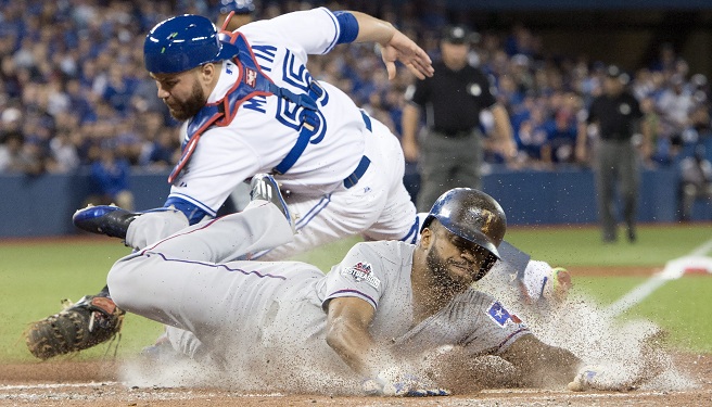 Texas Rangers&#039 Delino DeShields center scores past Toronto Blue Jays catcher Russell Martin during the third inning of Game 1 of the American League Division Series in Toronto on Thursday Oct. 8 2015