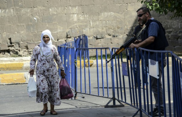 AFP  File  Ilyas AkenginA woman walks past Turkish police standing guard in central Diyarbakir where a shoot-out