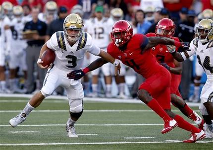 UCLA quarterback Josh Rosen gets away from Arizona safety Will Parks during the first half of an NCAA college football game Saturday Sept. 26 2015 in Tucson Ariz