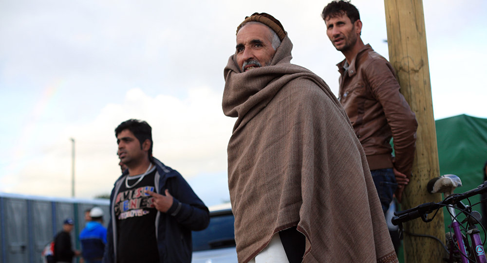 Afghan migrants stand in the Jungle of Calais northern France Friday Sept. 18 2015