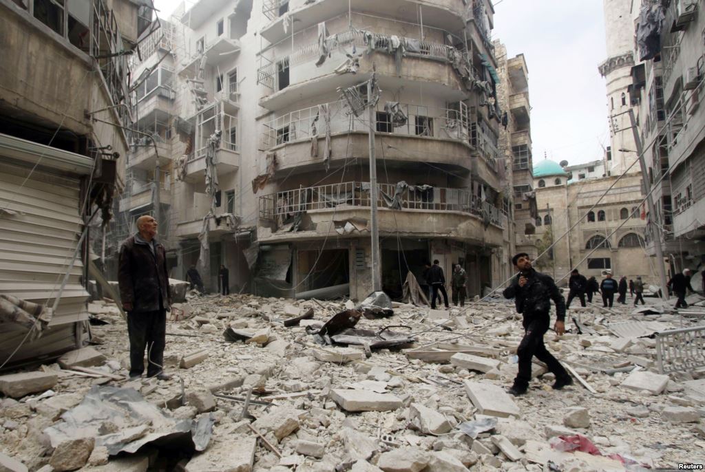 FILE- Men inspect damage at site of barrel bomb attack by forces loyal to Syria's President Bashar al-Assad al Shaar neighborhood Aleppo